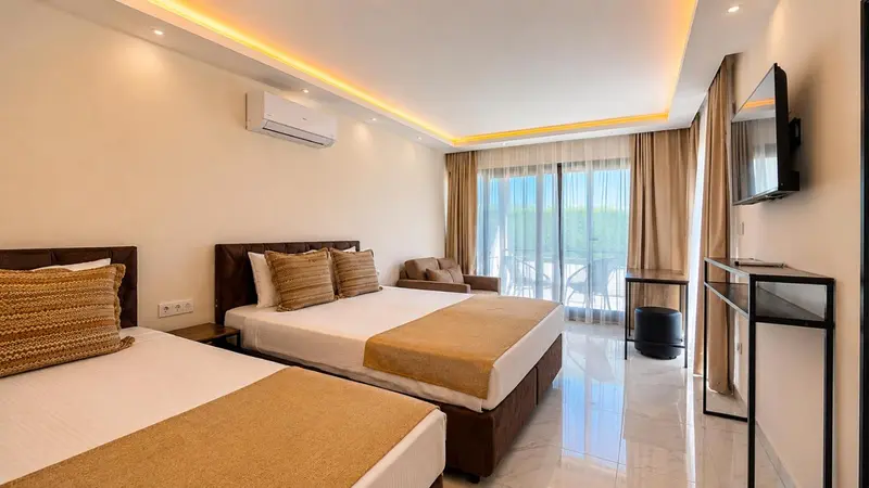 Une chambre lumineuse avec un lit double et un lit simple, donnant sur une terrasse.