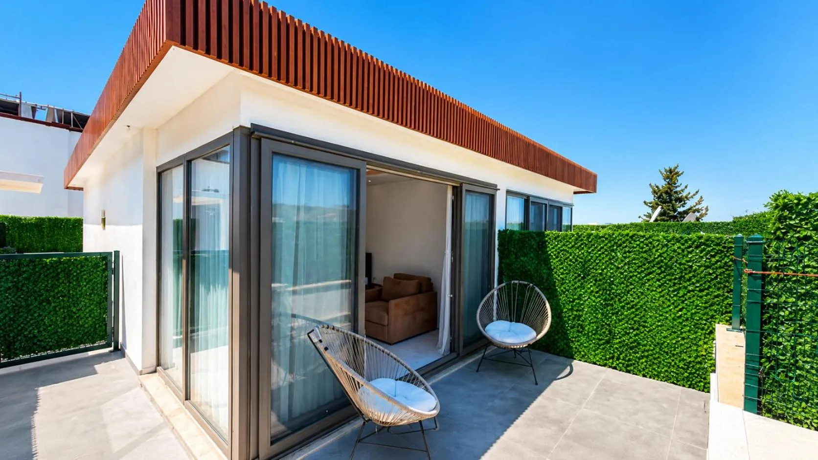 Terrasse avec mobilier d'extérieur donnant sur une pièce à vivre.