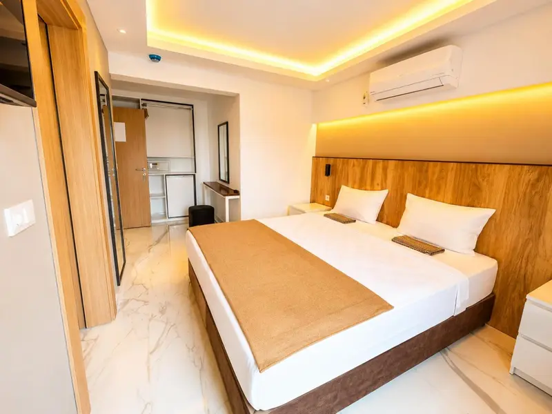 Une chambre lumineuse avec un grand lit et un décor moderne.