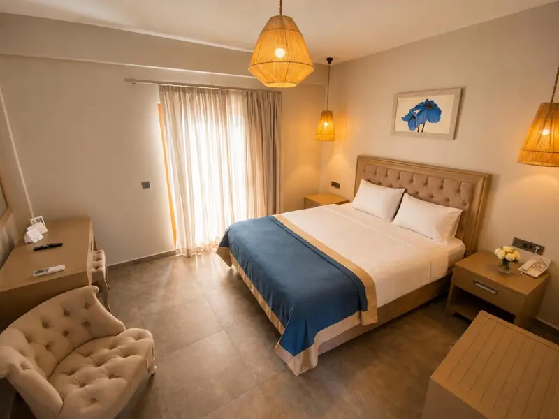 Une chambre lumineuse avec un grand lit et un fauteuil.