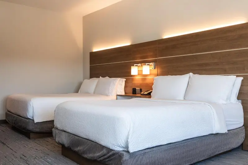 Une chambre lumineuse avec deux lits doubles et une décoration moderne.