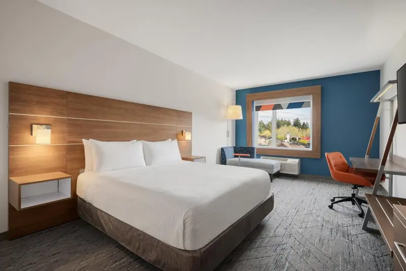 Une chambre d'hôtel lumineuse avec un grand lit et un espace de travail.