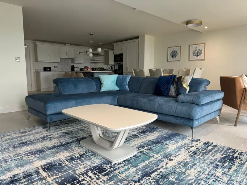 Un salon moderne avec un grand canapé bleu et une table basse.