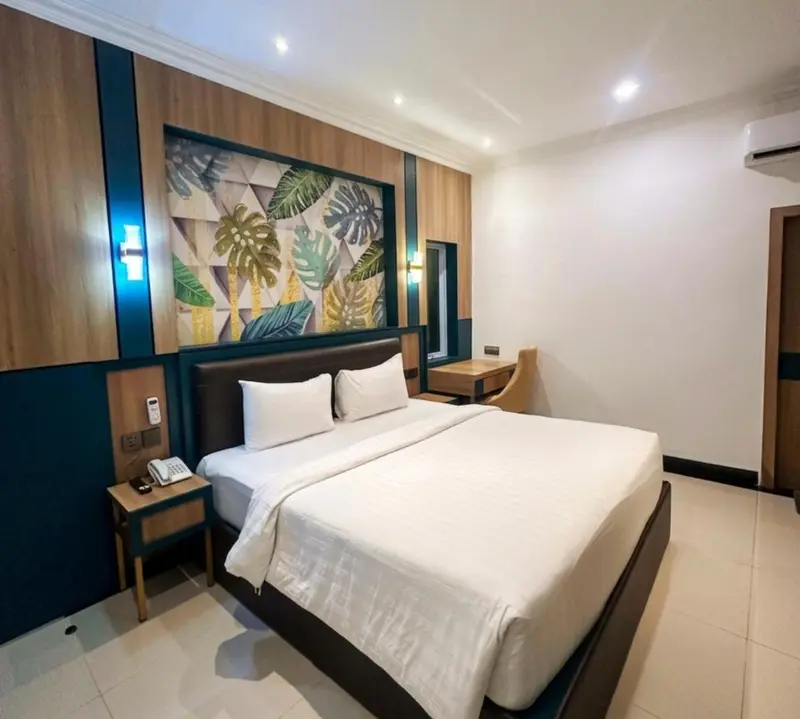 Une chambre lumineuse avec un grand lit et des tables de chevet.
