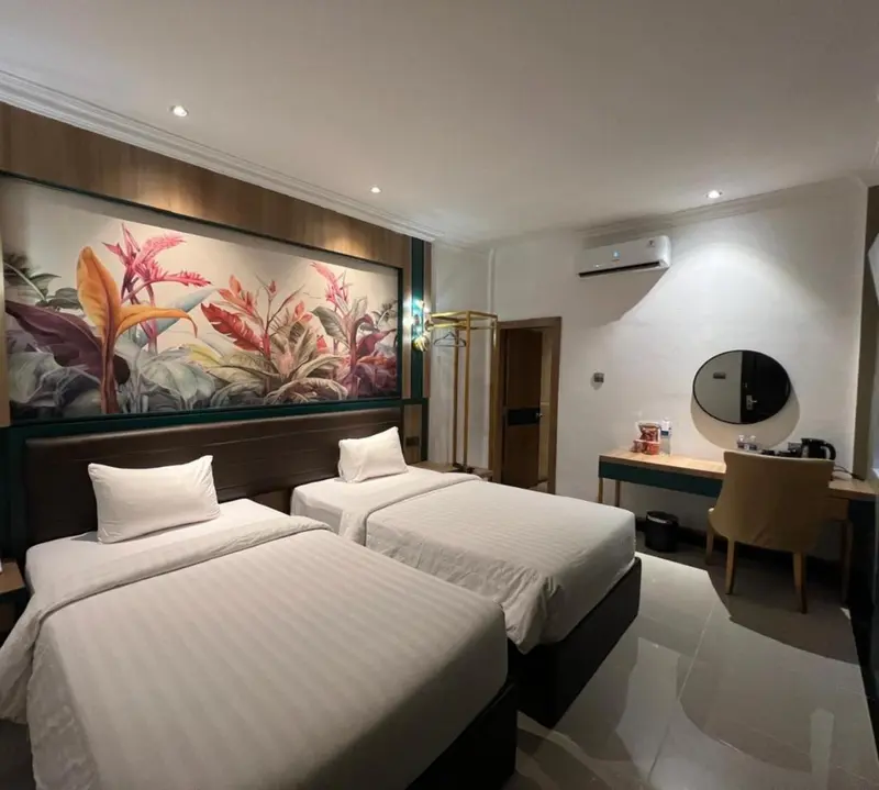Une chambre lumineuse avec deux lits simples et une décoration florale.