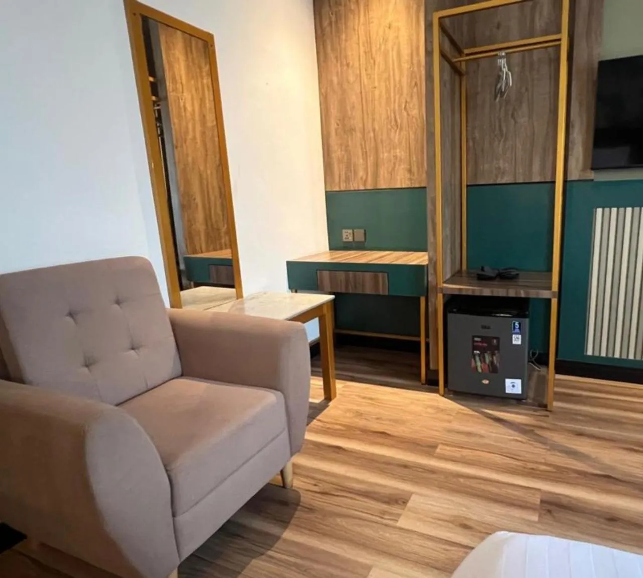 Un canapé et une table basse dans un espace de séjour décoré de panneaux de bois et de murs verts.