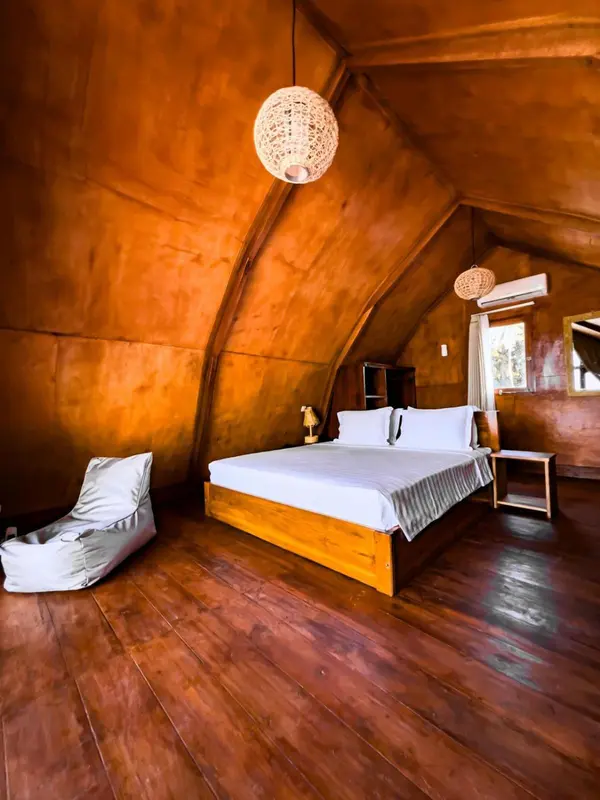 Une chambre à coucher lumineuse avec un lit simple et un fauteuil confortable.