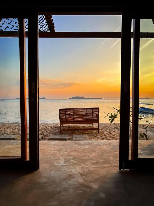 Une vue sur la mer et un coucher de soleil depuis une ouverture.