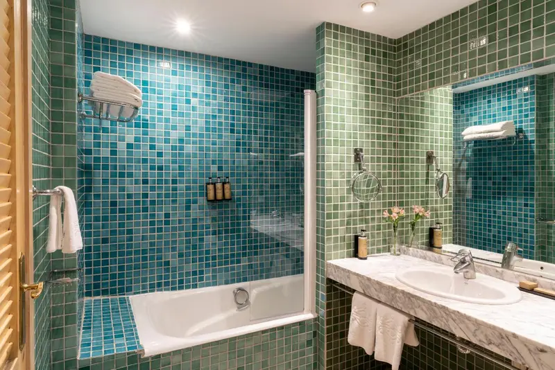 Une salle de bain lumineuse avec une baignoire et des murs carrelés.