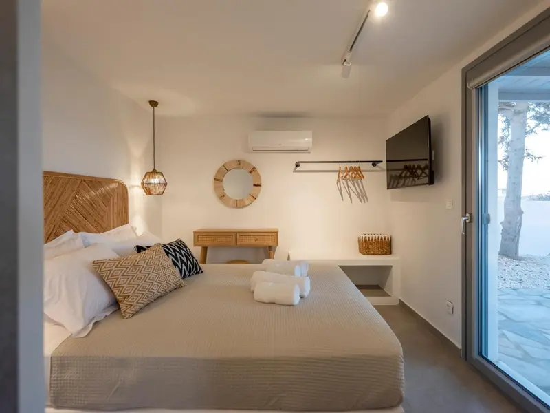 Une chambre lumineuse avec un grand lit et un accès à une terrasse.