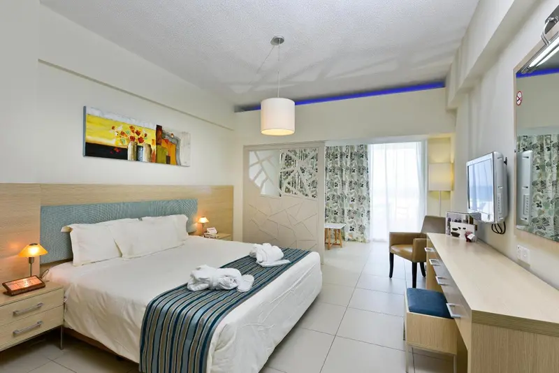 Une chambre lumineuse avec un grand lit et un espace bureau.
