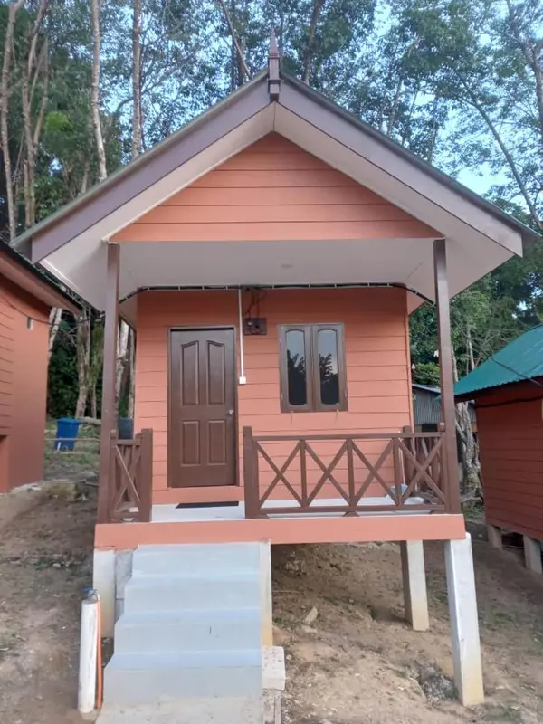 Petite maison en bois sur pilotis avec une terrasse couverte.