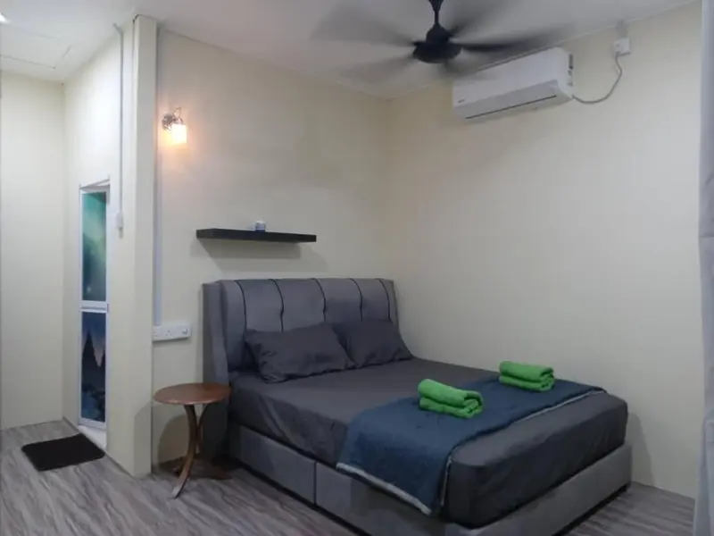 Une chambre lumineuse avec un lit double et une petite table de chevet.