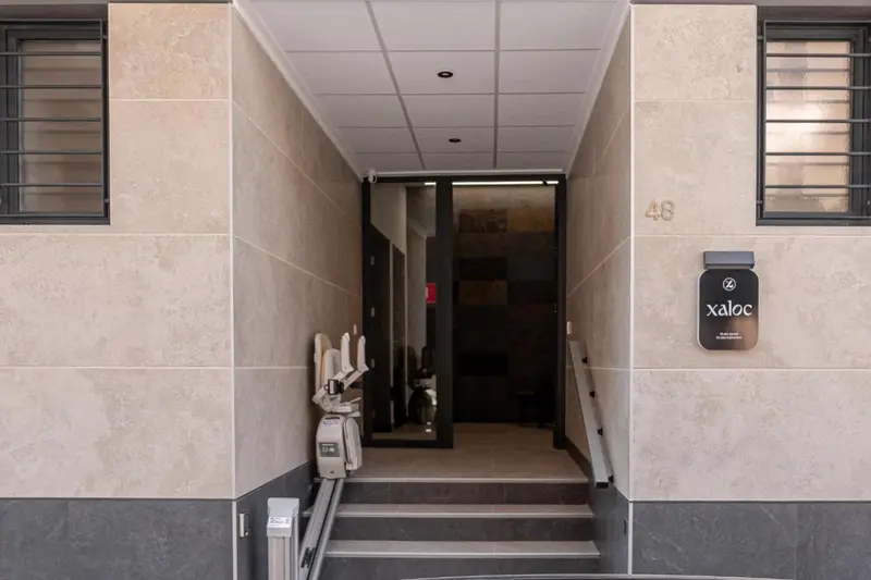 Entree d'un batiment avec un ascenseur pour personnes a mobilité reduite.