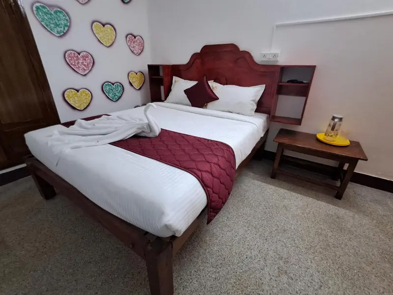 Une chambre avec un lit recouvert d'une courtepointe blanche et rouge.