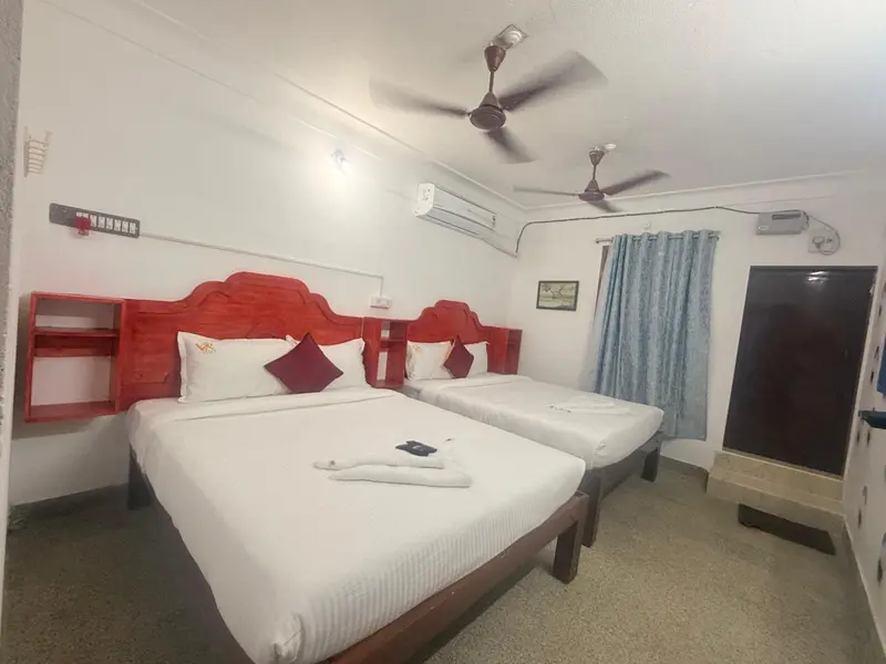 Une chambre lumineuse avec deux lits simples et une décoration colorée.