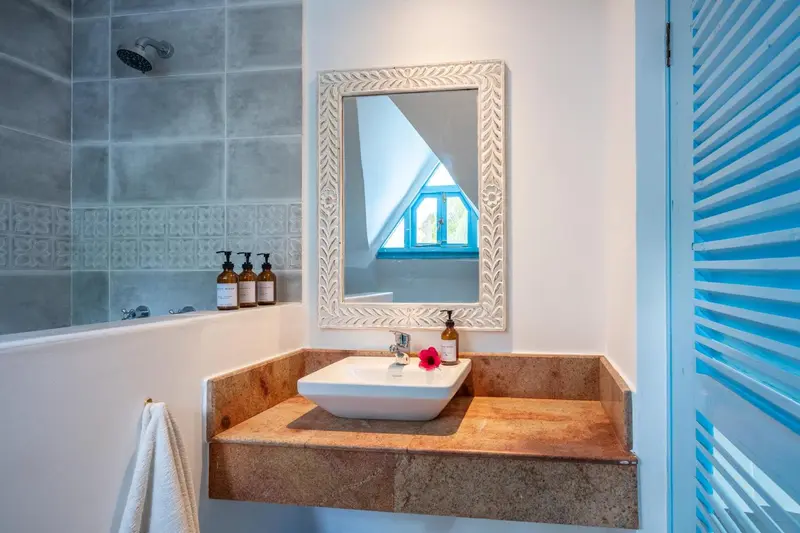 Une salle de bain lumineuse avec une douche à l'italienne et un lavabo sur un meuble.
