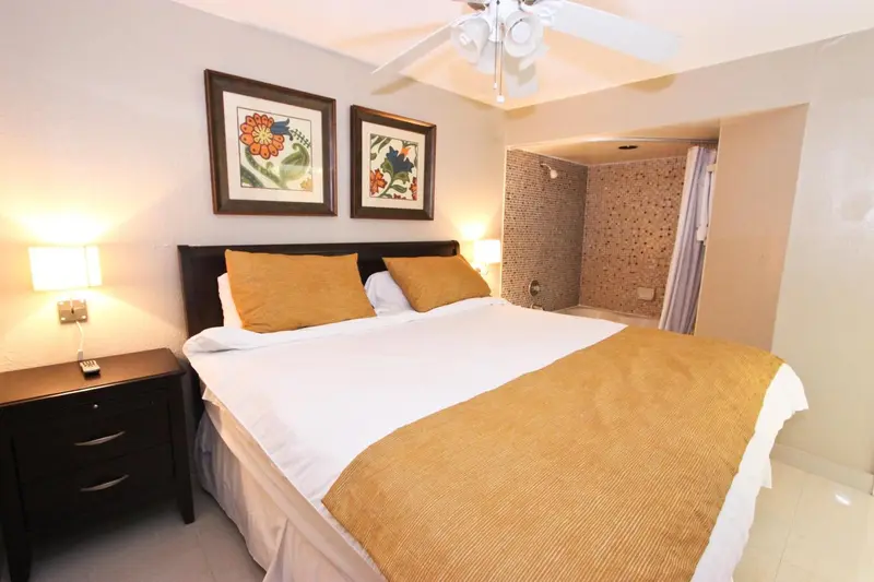 Une chambre lumineuse avec un grand lit recouvert d'une courtepointe.