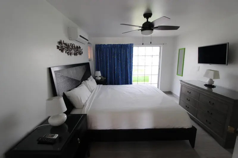 Une chambre lumineuse avec un grand lit et une commode.