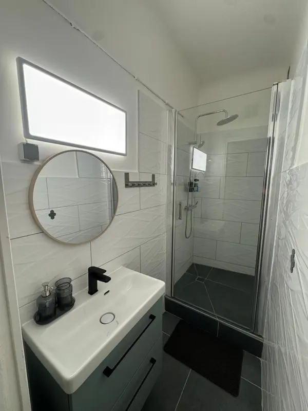 Une salle de bain moderne avec douche à l'italienne et lavabo.