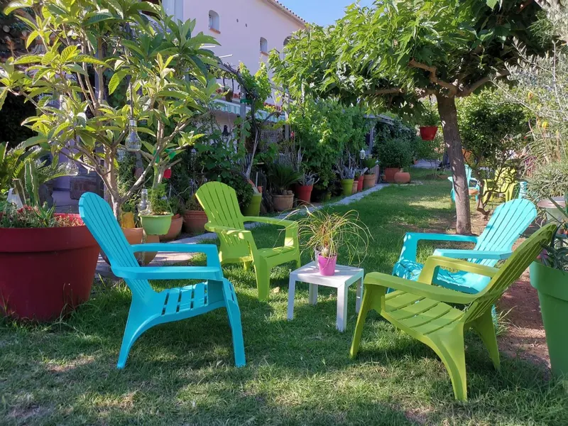 Mobilier de jardin coloré disposé sur une pelouse verdoyante.