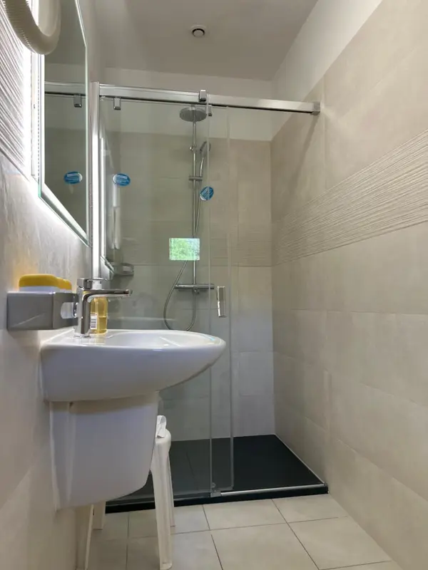 Une salle de bain moderne avec douche à l'italienne et lavabo.