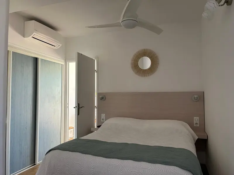 Une chambre lumineuse avec un lit recouvert d'une courtepointe verte.