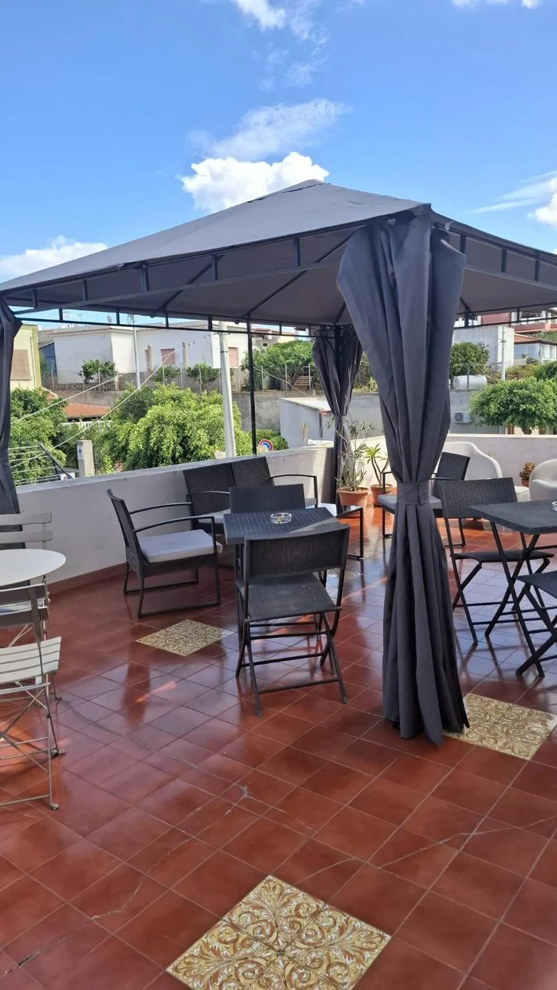 Terrasse ombragée avec tables et chaises pour se détendre.