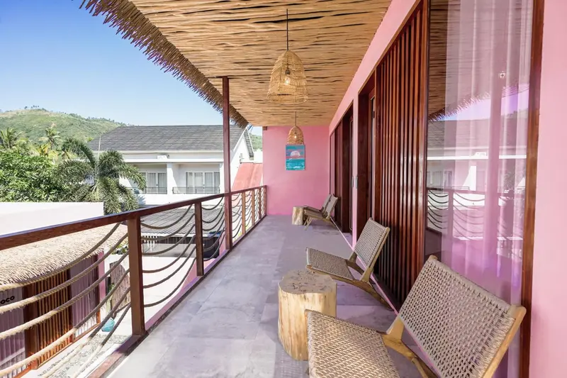 Terrasse ombragée avec mobilier en bois et vue sur la végétation.