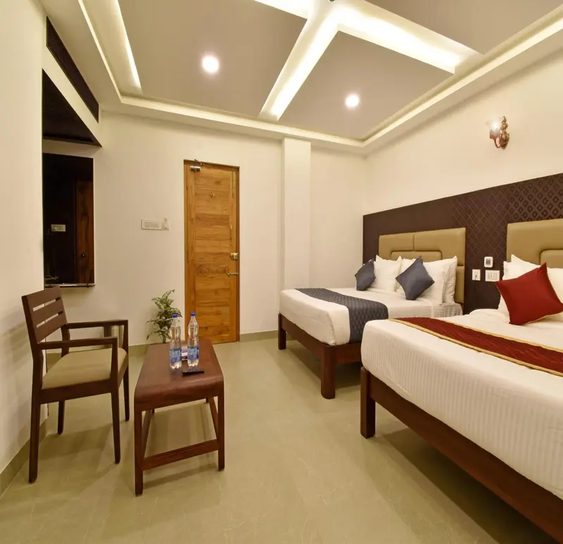 Une chambre lumineuse avec deux lits et un coin salon.
