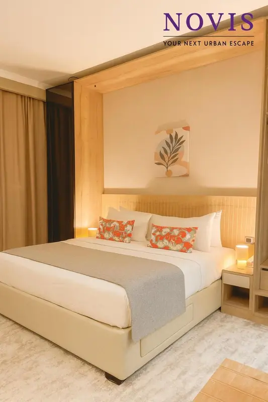 Une chambre lumineuse avec un grand lit recouvert d'une courtepointe et de coussins.
