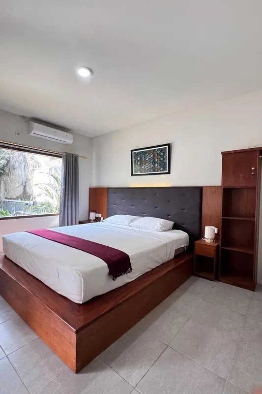 Une chambre lumineuse avec un grand lit et une décoration sobre.