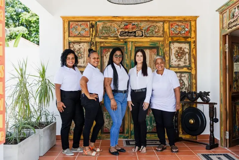 Groupe de personnes souriantes posant devant une porte décorée.