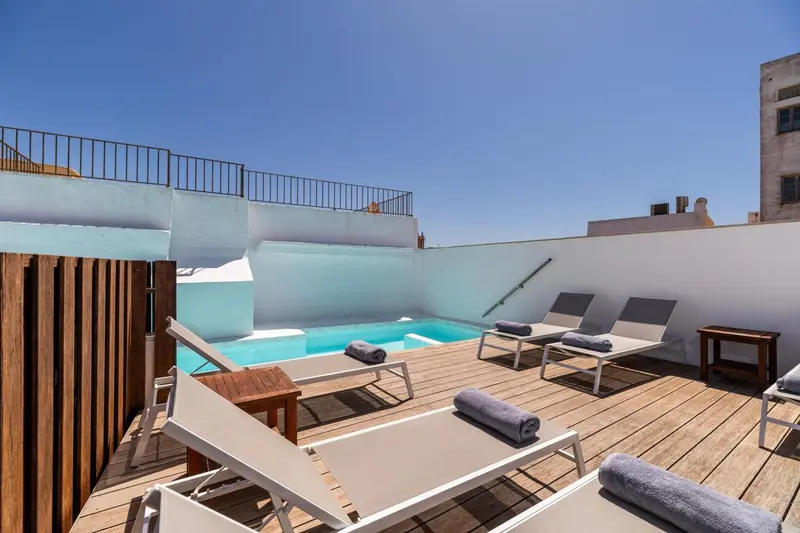 Terrasse avec piscine et chaises longues sur toit plat.