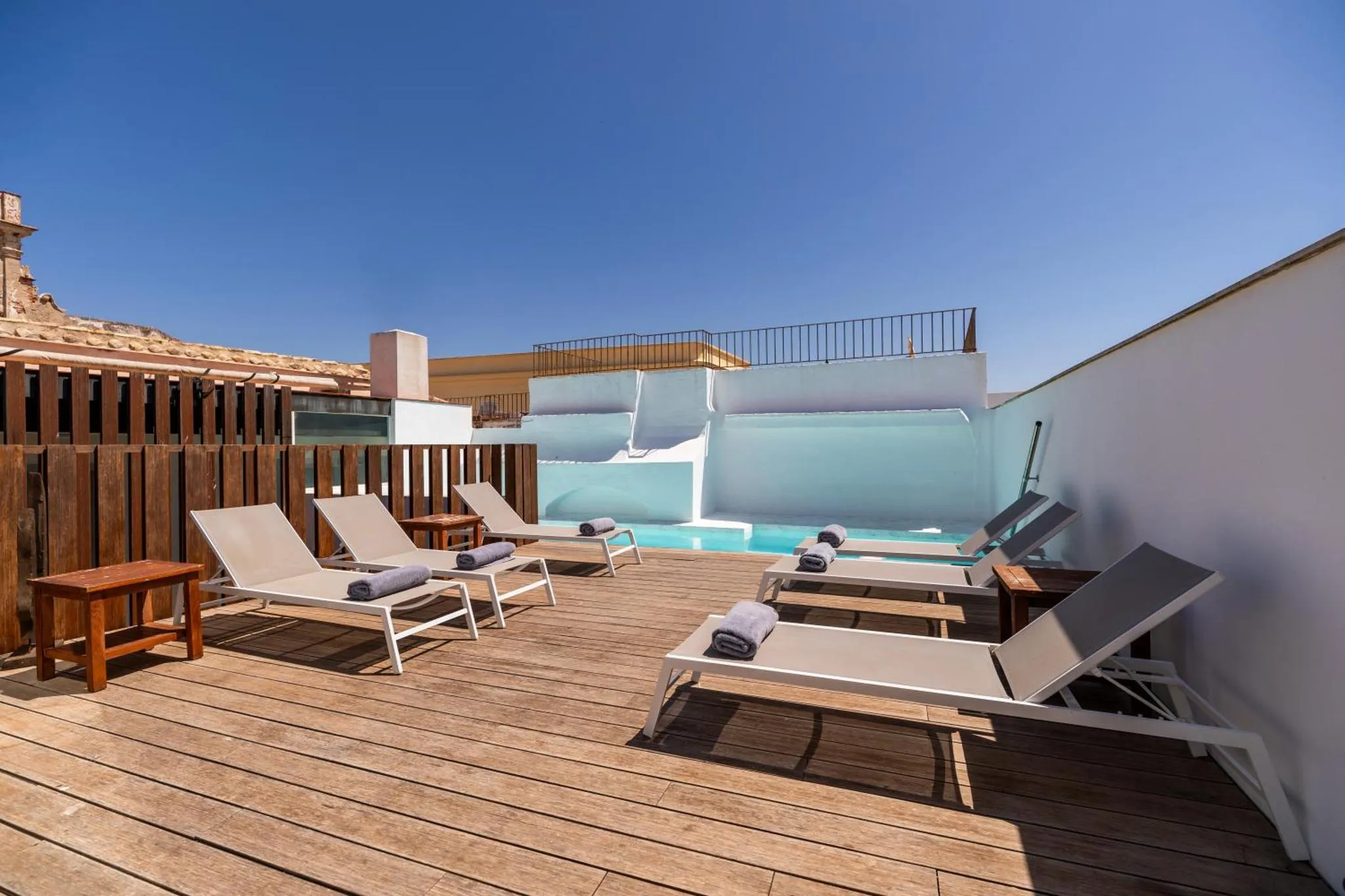 Terrasse avec transats et petite piscine sur toit.