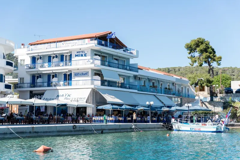 Bâtiment blanc avec des balcons et des auvents au bord de l'eau.