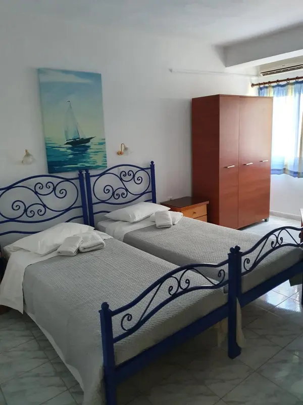 Une chambre lumineuse avec deux lits simples et une décoration marine.