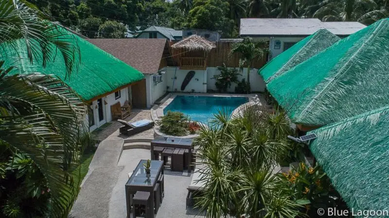 Vue aérienne d'une piscine entourée de bâtiments à toits de chaume.