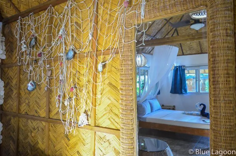 Une chambre lumineuse avec un lit recouvert d'une moustiquaire et une décoration marine.