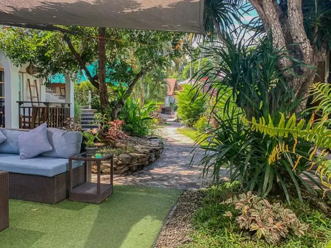 Un espace de détente extérieur avec des canapés et une végétation luxuriante.