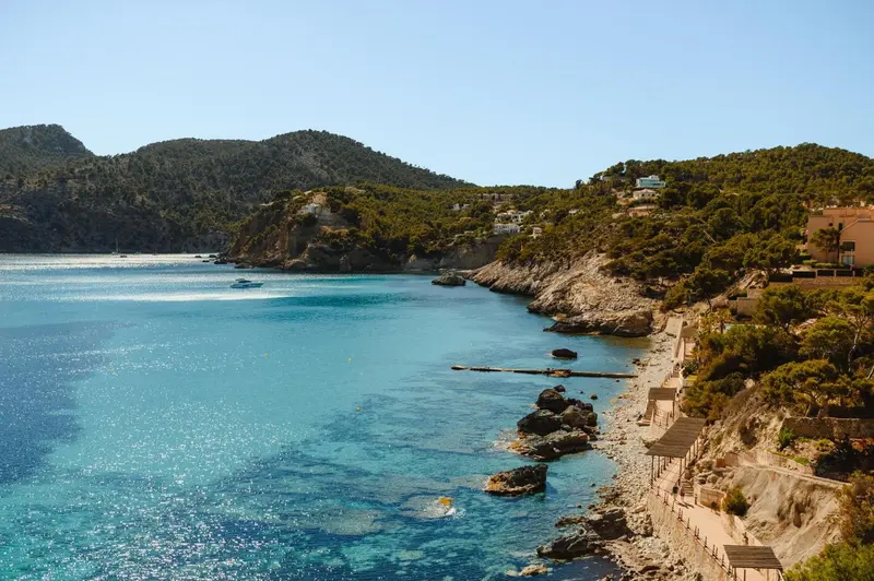 Vue d'une crique abritée avec des bateaux amarrés dans une eau turquoise.