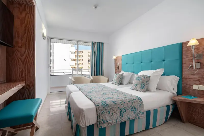 Une chambre lumineuse avec un grand lit et un accès à un balcon.