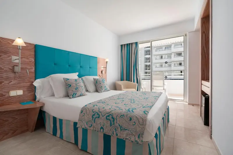 Une chambre lumineuse avec un grand lit et un accès à une terrasse.