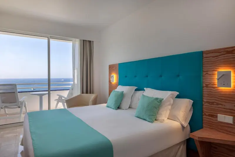 Une chambre lumineuse avec un grand lit et une vue sur la mer.