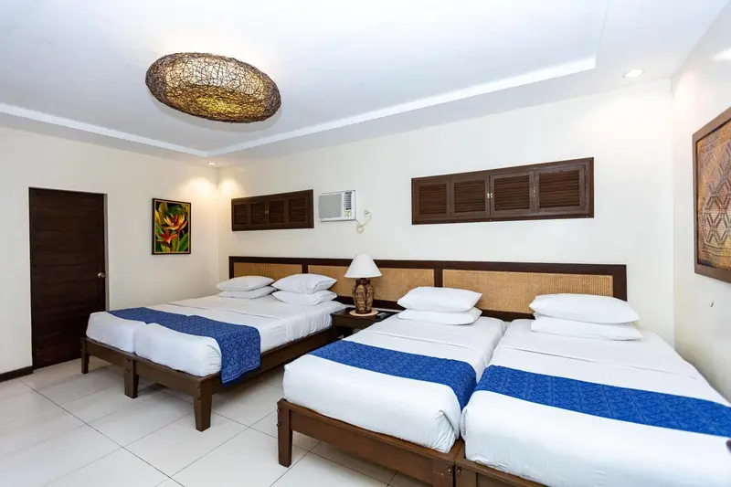 Une chambre lumineuse avec deux lits simples et une décoration sobre.