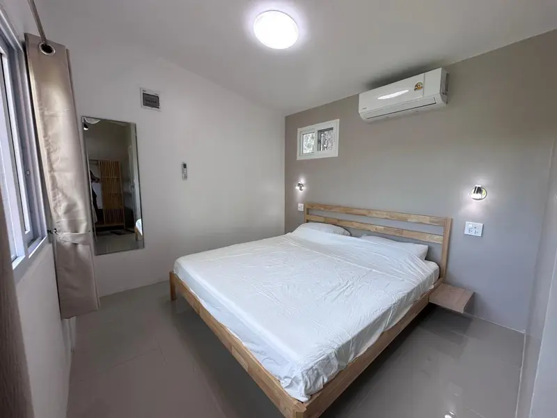 Une chambre lumineuse avec un grand lit et un miroir.