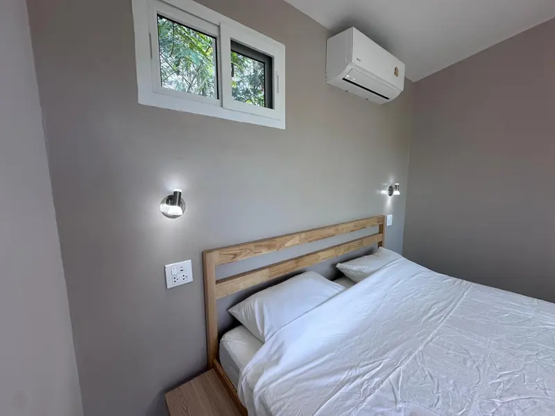 Une chambre lumineuse avec un lit simple et des appliques murales.
