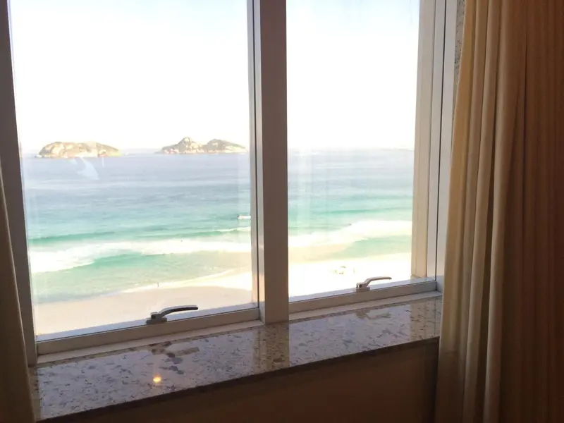 Vue sur la mer depuis une fenêtre de chambre.