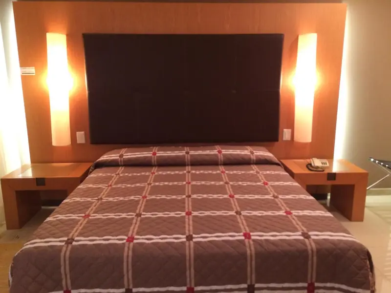 Une chambre avec un grand lit recouvert d'une courtepointe à motifs.