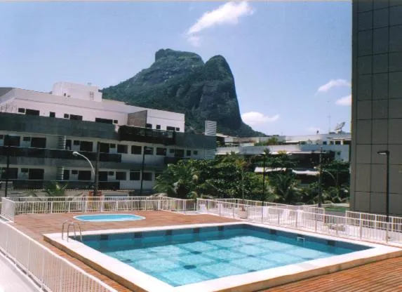 Une piscine sur une terrasse avec une vue sur une montagne et des bâtiments.